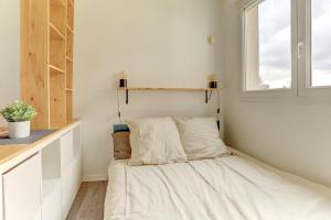 Bett in der Ecke eines Zimmers mit Fenster in der Unterkunft Le Sevestre - Plaisir in Plaisir