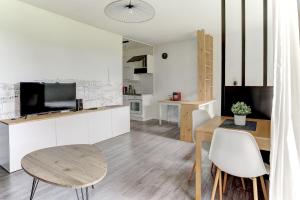 una cucina e un soggiorno con tavolo e sedie di Le Sevestre - Plaisir a Plaisir
