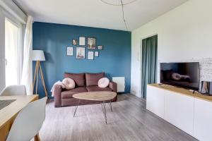 ein Wohnzimmer mit einem Sofa und einem TV in der Unterkunft Le Sevestre - Plaisir in Plaisir