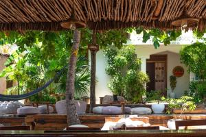 a resort with a hammock and chairs and trees at Dar Mar Hostel & Coworking in Paje