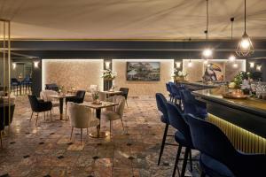 グラートベックにあるホテル グラートベック ファン デア ファルクのテーブルと椅子のあるレストラン、バー