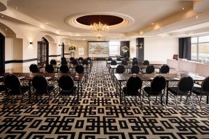 une salle de conférence avec des tables et des chaises ainsi qu'un lustre dans l'établissement Hotel Gladbeck van der Valk, à Gladbeck