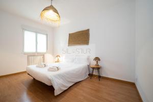 een slaapkamer met een groot wit bed in een kamer bij Vive Oviedo I Apartamento in Santa Eulalia
