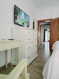 a bedroom with a white dresser with a tv on the wall at Jaime III - Palma center - Luxury Suites in Palma de Mallorca
