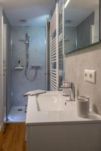 La salle de bains est pourvue d'un lavabo blanc et d'une douche. dans l'établissement Ferienwohnung Vergissmeinnicht Sauerland, à Schmallenberg