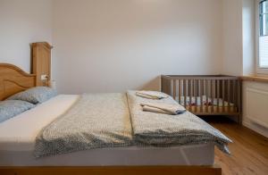 - un lit avec une couverture et un lit bébé dans une chambre dans l'établissement Ferienwohnung Vergissmeinnicht Sauerland, à Schmallenberg