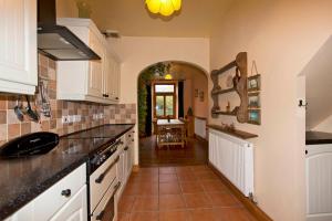 a kitchen with white cabinets and a tile floor at Uplands Newport, Pembrokeshire in Newport Pembrokeshire