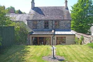 an external view of a stone house with a yard at Uplands Newport, Pembrokeshire in Newport Pembrokeshire