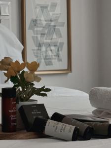 雅典的住宿－Voulis Best Global Home，床上有两瓶马斯卡拉和鲜花