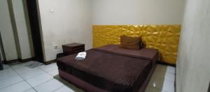 a bedroom with a bed with a yellow headboard at New Arcadia Residence in Jakarta +1 photo