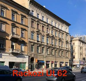 um grande edifício numa rua da cidade com carros estacionados em frente em Rackozi apt em Budapeste