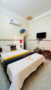 a bedroom with a large bed and a television at Khách Sạn Thiên Trí Lý Sơn in Ly Son