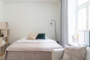 1 dormitorio blanco con 1 cama y 1 silla en Cozy Studio with private Sauna en Helsinki