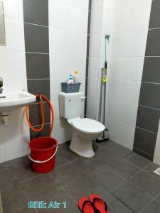 a bathroom with a toilet and a sink and a bucket at FJ Homestay in Seri Iskandar