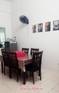 a dining room table with four chairs and a red blanket on it at FJ Homestay in Seri Iskandar