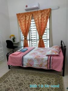 a bedroom with a bed with a pink blanket and a window at FJ Homestay in Seri Iskandar