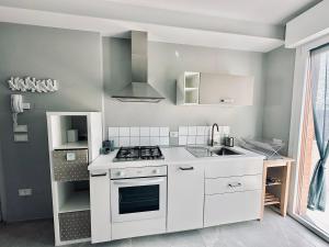a white kitchen with a stove and a sink at OliVia Home Sauna & Gym in Forlì