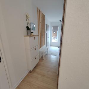 een hal met een witte dressoir en een spiegel bij Les Cactus in Grisolles