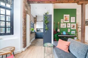 ALTIDO Stylish flat near London Bridge في لندن: غرفة معيشة مع أريكة زرقاء وجدار أخضر