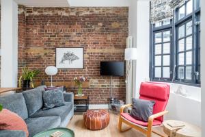 ALTIDO Stylish flat near London Bridge في لندن: غرفة معيشة مع أريكة وجدار من الطوب