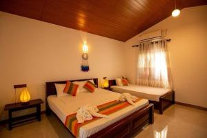 a bedroom with two beds with stuffed animals on them at Jim Dandy House in Tissamaharama