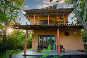 a small yellow house with a roof at Jim Dandy House in Tissamaharama