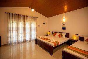 a bedroom with two beds and a large window at Jim Dandy House in Tissamaharama