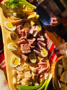 a wooden cutting board filled with different types of food at Pensiunea Teodora in Moisei