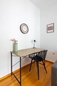 a desk with a chair and a clock on a wall at Feels like home apartment next to Acropolis in Athens