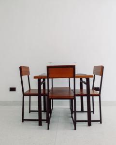 瓦塔姆的住宿－Trio Villas Watamu，两张椅子、一张木桌、一张桌子和两把椅子