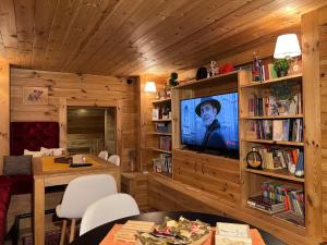 Chalet Kolašin في كولاسين: غرفة معيشة مع تلفزيون ورف كتاب
