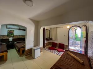 a living room with a bed and a bedroom at Club Red Dahab Motel in Dahab