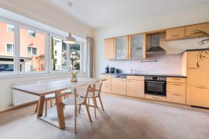 une grande cuisine avec une table et des chaises en bois dans l'établissement Stylische Altbauwohnung Bregenz am See, à Bregenz