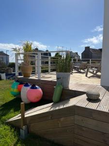 a wooden deck with some plants and pots on it at L'Atelier de Mézareun in Ouessant