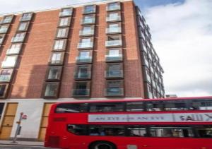 a red double decker bus parked in front of a building at Westminster 1 bed apt with terrace in London