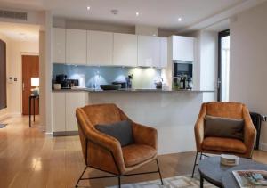 a living room with two chairs and a kitchen at Westminster 1 bed apt with terrace in London