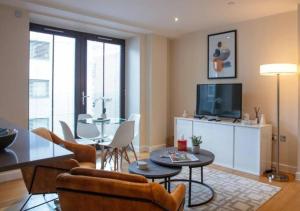 - un salon avec une télévision, une table et des chaises dans l'établissement Westminster 1 bed apt with terrace, à Londres