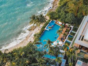 パタヤ・ノースにあるCape Dara Resort - SHA Plusのプールとビーチの空中を望む