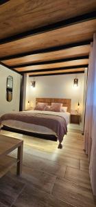 1 dormitorio con 1 cama grande y techo de madera en Loft Puerta Almodovar, en Córdoba
