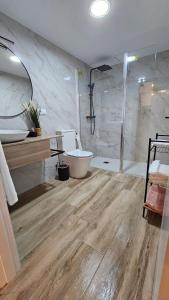 y baño con ducha, aseo y bañera. en Loft Puerta Almodovar, en Córdoba