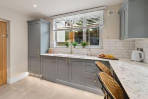 una cocina con fregadero y ventana en Archways Tenby, en Pembrokeshire