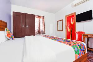 a bedroom with a white bed and a tv at FabHotel Angelo's Inn in Calangute