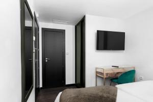 1 dormitorio con puerta negra y escritorio en Hotel Los Girasoles, en Granada