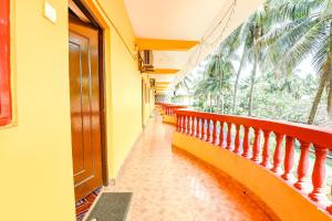 a hallway with a balcony with a view of palm trees at FabHotel Angelo's Inn in Calangute