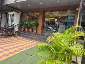 a motorcycle parked in front of a building with plants at Hotel Sky Park in Shamshabad