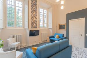 a living room with a blue couch and two chairs at Cinque Giornate 70 Suites by Rent All Como in Como