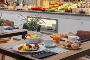Una mesa cubierta con platos de desayuno y café. en Catalonia Puerta del Sol, en Madrid