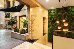 un vestíbulo con una pared verde con plantas en Catalonia Puerta del Sol, en Madrid 35 fotos más