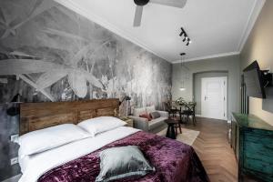 ein Schlafzimmer mit einem großen Bett und einem Wandbild in der Unterkunft Hidden jewel - Right in the centre of Prague in Prag