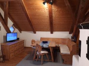 a room with a wooden table and a desk with a computer at Altes Forsthaus in Riedlhütte